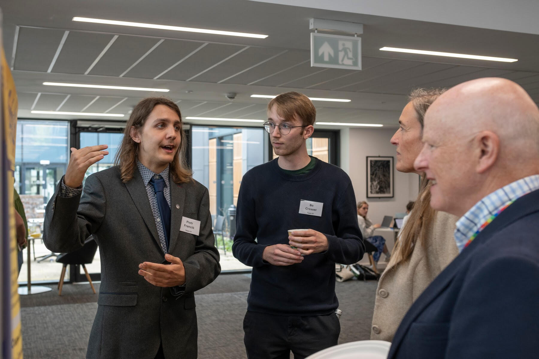 APUC Piotr and Bo are talking with Aegis Professor Undergraduate Competition judges about their poster and business idea